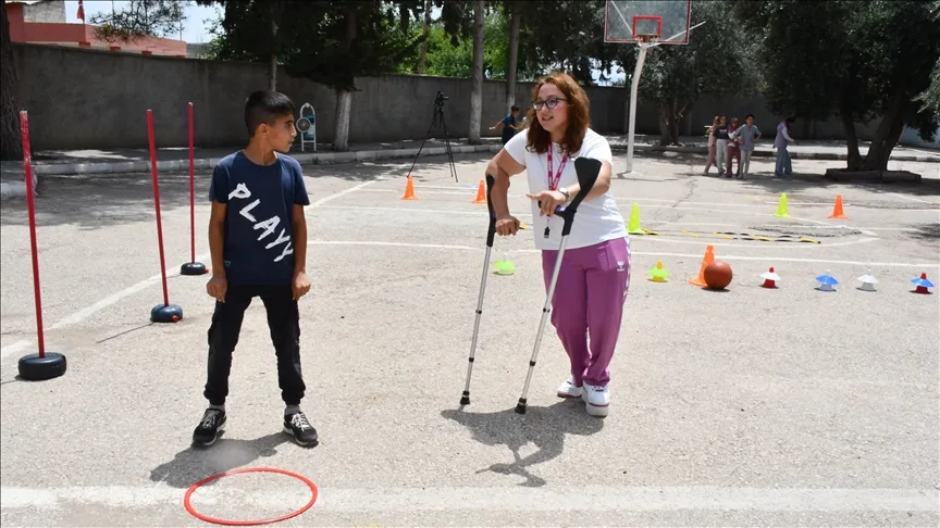 Koltuk değnekli beden eğitimi öğretmeni, öğrencilerini sporla buluşturuyor