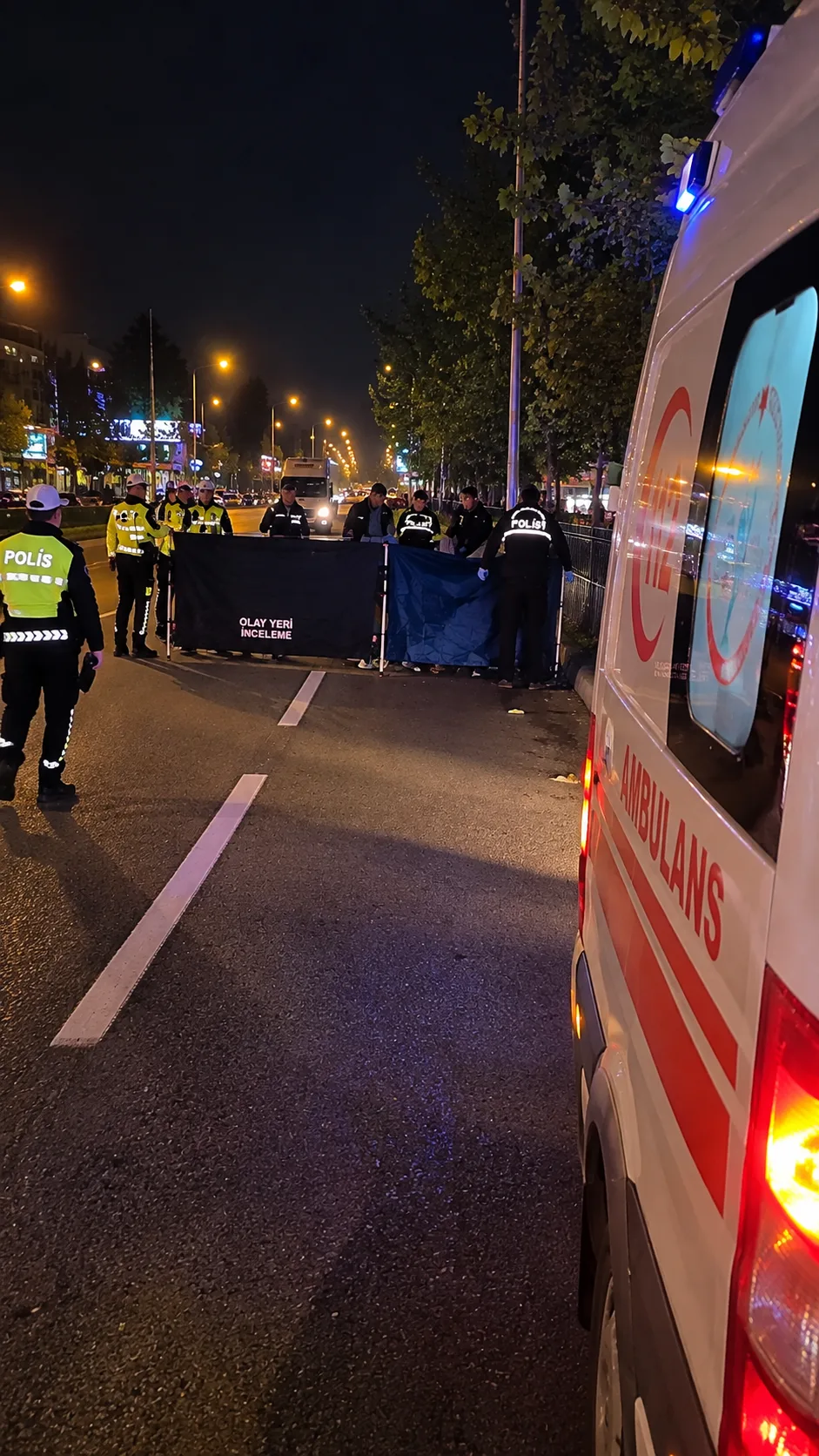 İnegöl’de gece olay yerini inceleyen polis ekipleri, ambulansın yanında güvenlik önlemi alıyor.