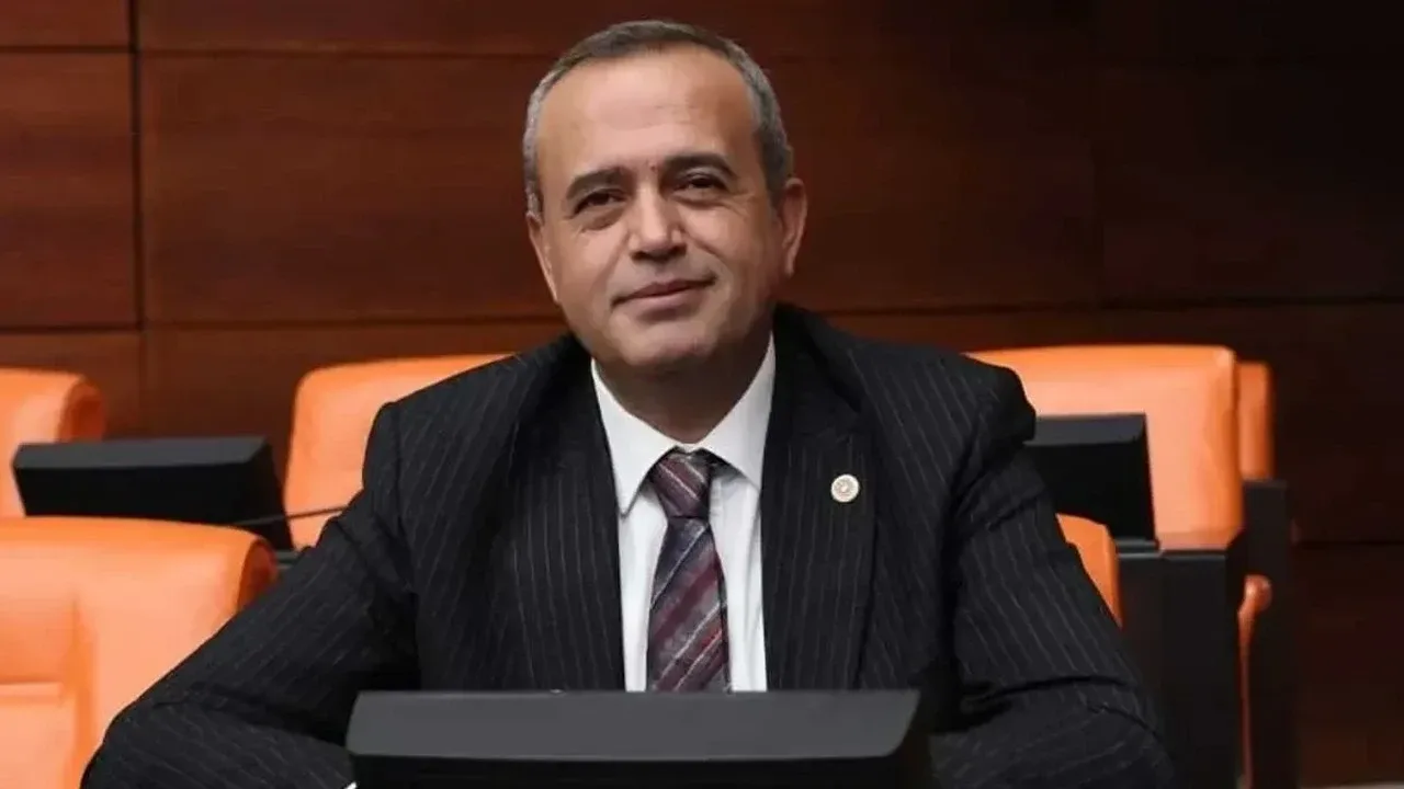 DEVA Partisi Gaziantep Milletvekili Ertuğrul Kaya, Meclis salonunda takım elbiseyle oturuyor.